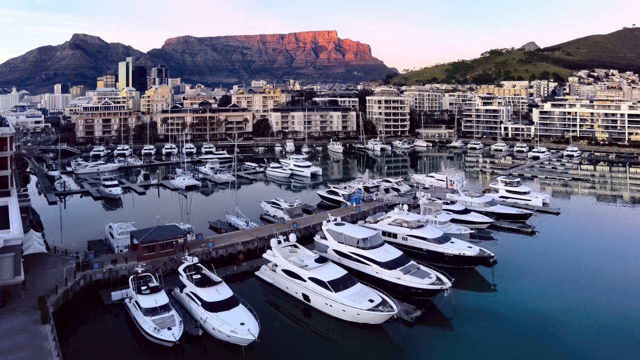 services-03 A stunning aerial view of Cape Town's marina with yachts and Table Mountain in the background during daylight.